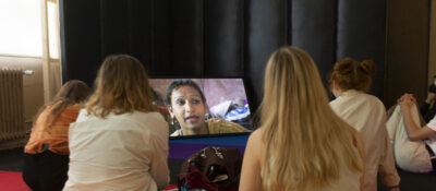 Ansicht aus der Ausstellung "Das Dritte Geschlecht"; zu sehen ist ein Ausschnitt aus dem Film "Between the Lines – Indiens drittes Geschlecht" von Thomas Wartmann