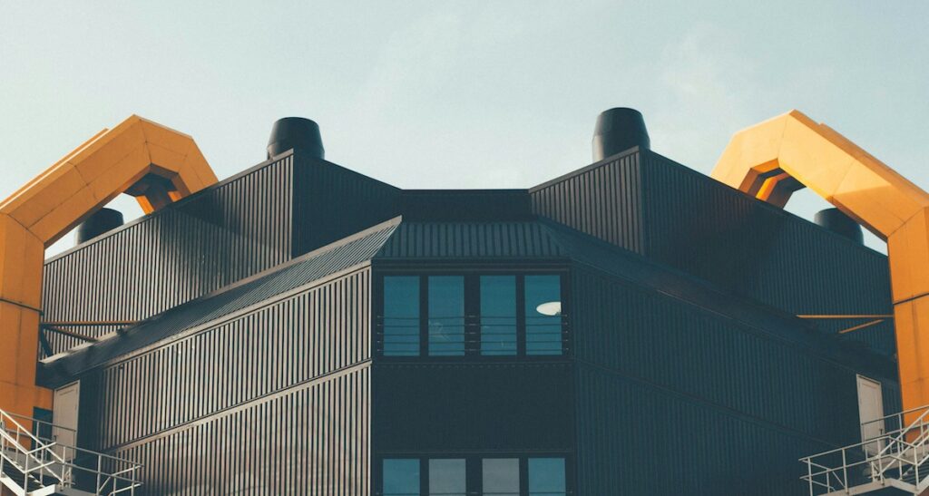 Ein brutalistisches Gebäude mit einer schwarzen und orangenen Bleckverkleidung.